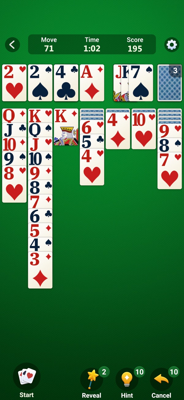 A game of Klondike Solitaire on a green card table